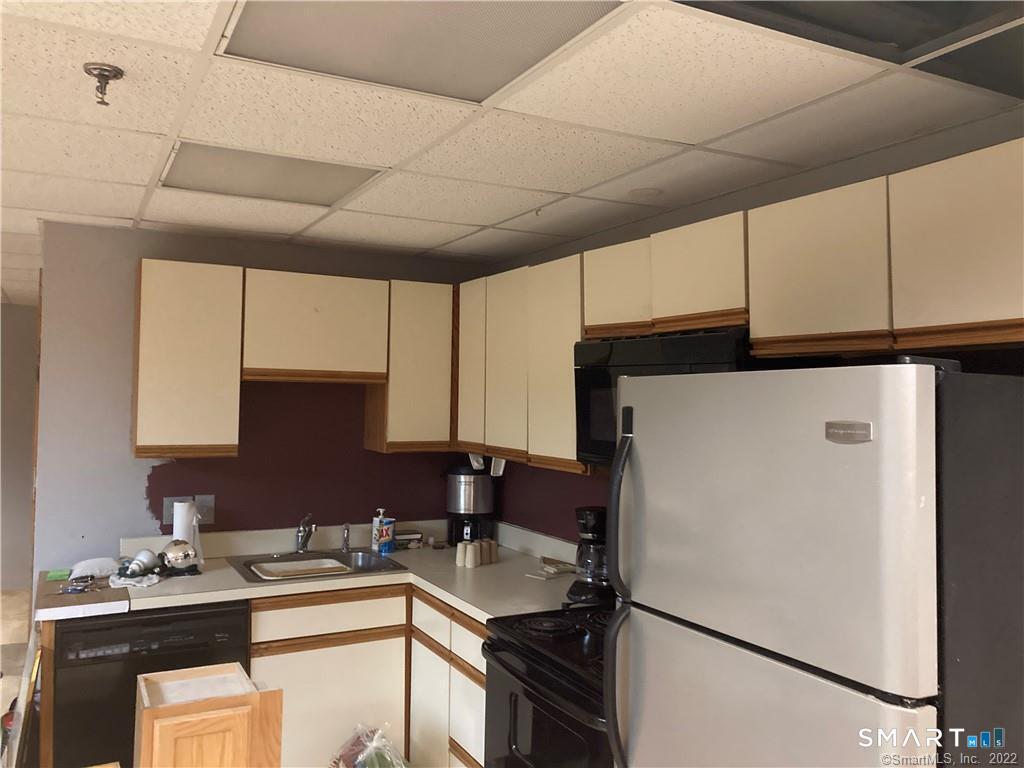 96 Putter Drive, Unit 510N Wallingford, CT 06492 - Photo 22 of 23 a kitchen with a sink a refrigerator and cabinets