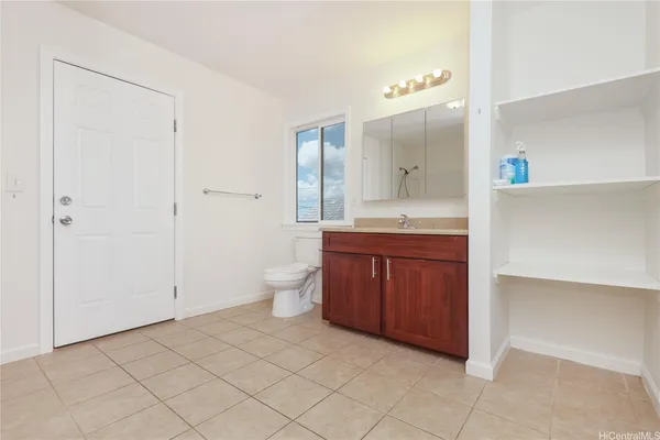 a spacious bathroom with a granite countertop sink toilet and mirror