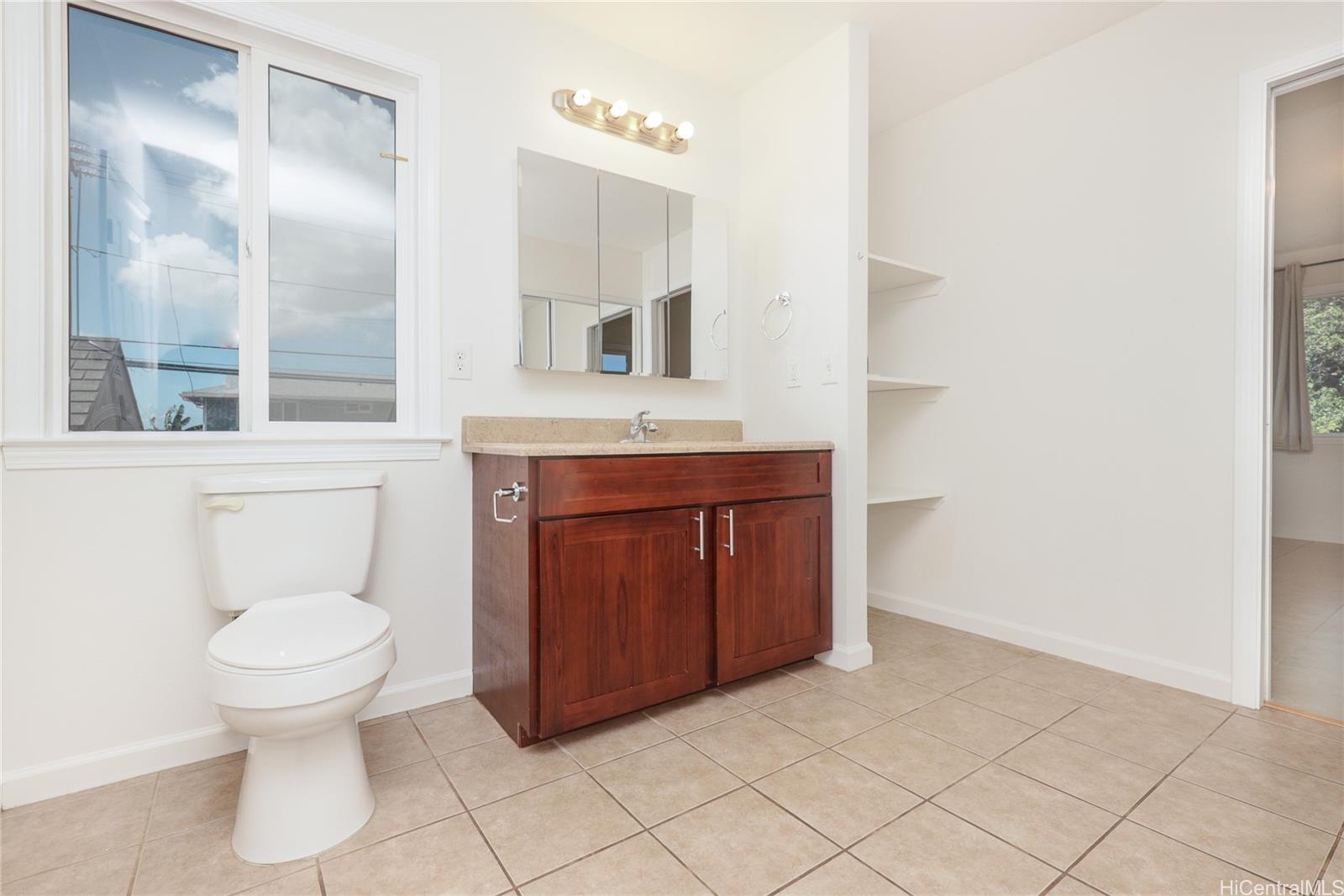 99-036 Moanalua Road, Unit A1 Aiea, HI 96701 - Photo 12 of 18 a bathroom with a toilet a sink and mirror