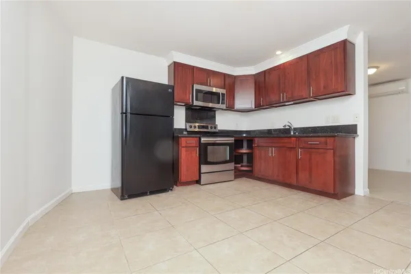 a kitchen with stainless steel appliances granite countertop a refrigerator and a stove top oven
