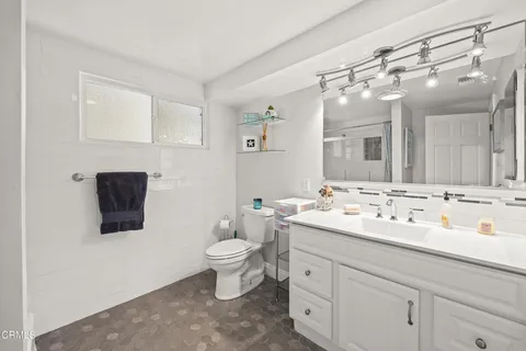 a bathroom with a toilet sink double vanity and mirror