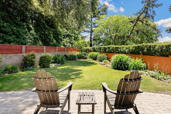 a view of a house with swimming pool lawn chairs and a yard