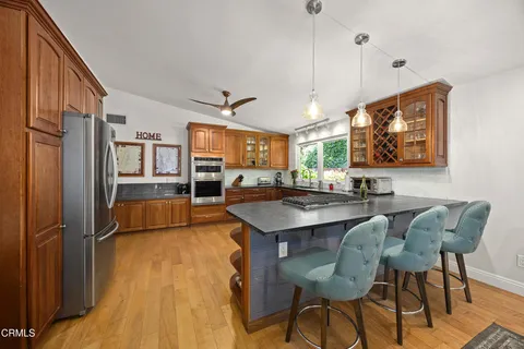 a kitchen with stainless steel appliances granite countertop a sink a stove and refrigerator