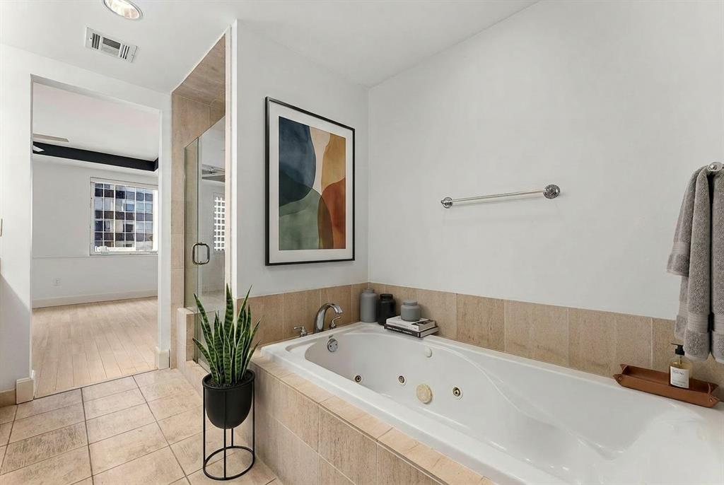 1505 Elm Street, Unit 1003 Dallas, TX 75201 - Photo 11 of 20 a bathroom with a tub a potted plant and a shower