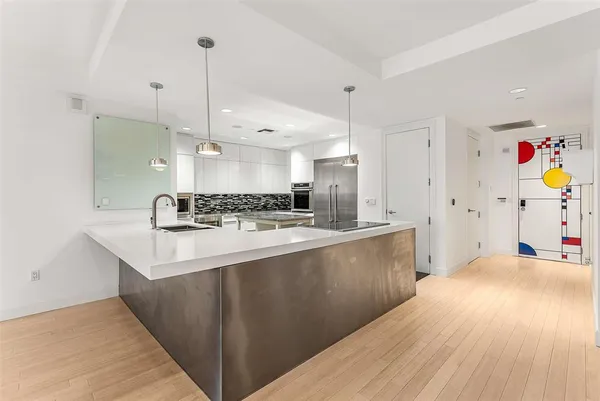 a kitchen with stainless steel appliances granite countertop a sink stove and wooden floor
