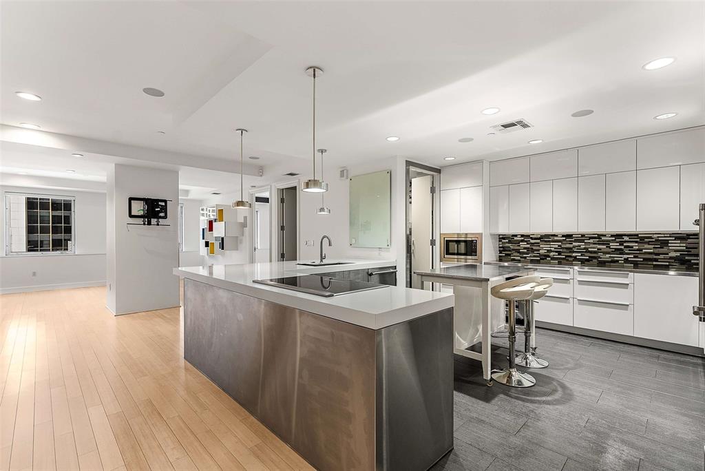 1505 Elm Street, Unit 1003 Dallas, TX 75201 - Photo 4 of 33 a kitchen with stainless steel appliances granite countertop a sink stove and wooden floor