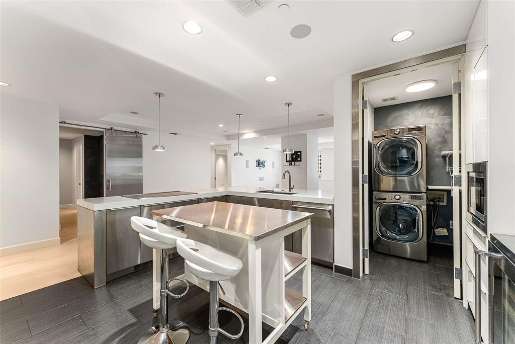 1505 Elm Street, Unit 1003 Dallas, TX 75201 - Photo 6 of 33 a kitchen with a table chairs refrigerator and cabinets