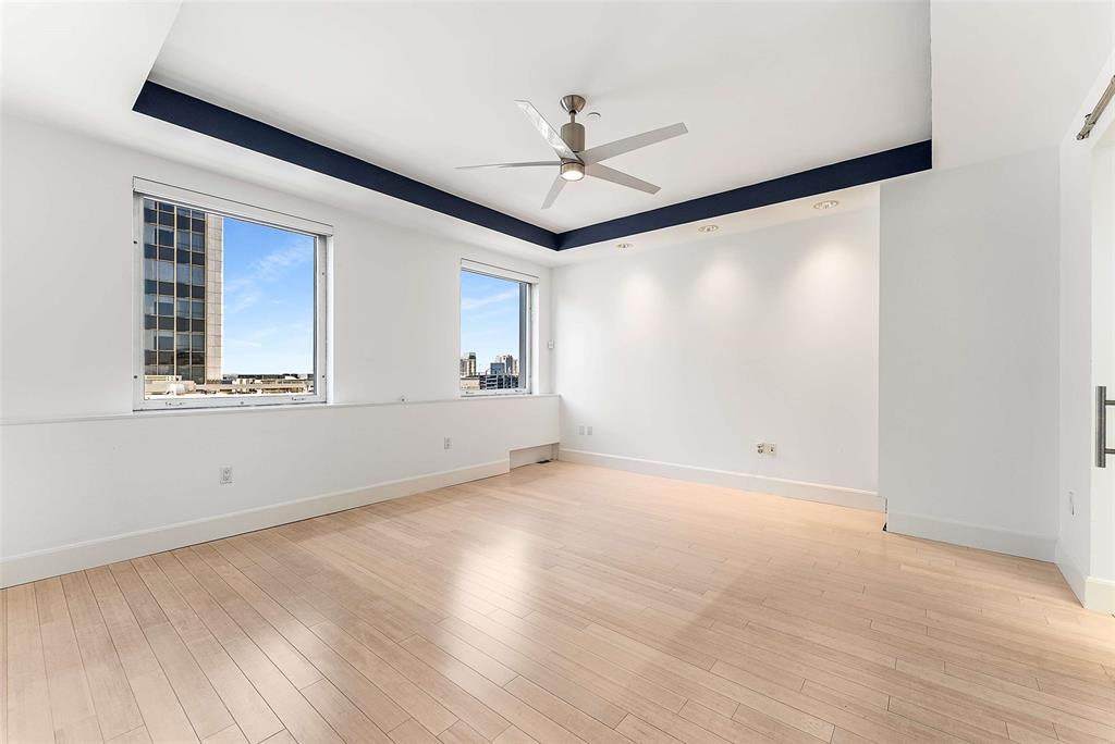 1505 Elm Street, Unit 1003 Dallas, TX 75201 - Photo 8 of 33 an empty room with a ceiling fan and windows