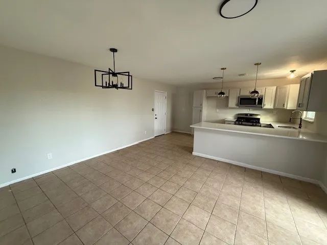 a kitchen with granite countertop a sink cabinets and stainless steel appliances