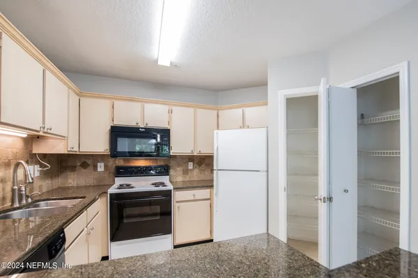 a kitchen with a refrigerator stove and sink