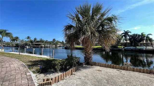 a bedroom with a bed and dresser with wooden floor