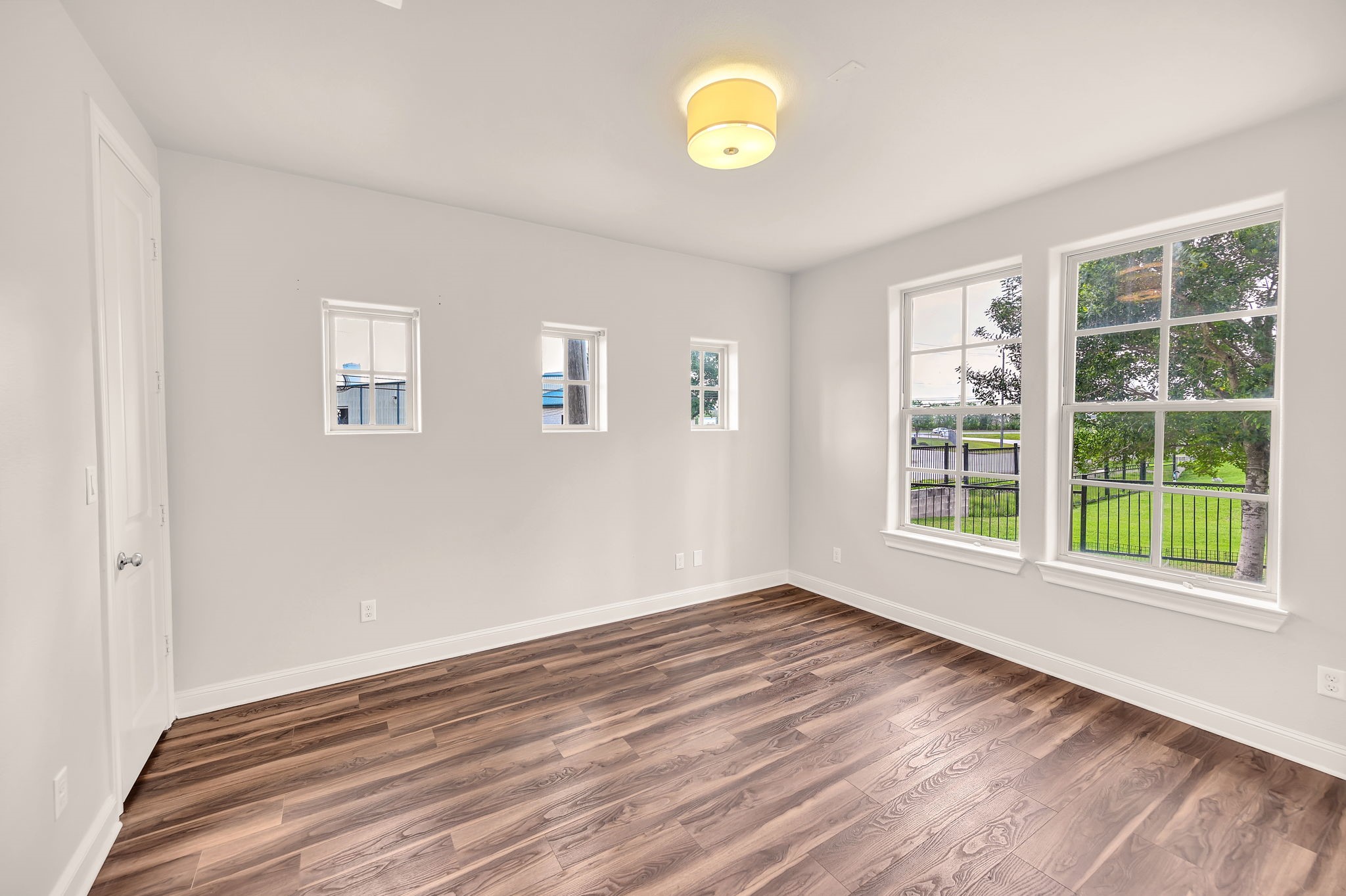 9644 Knight Road Houston, TX 77045 - Photo 5 of 28 a view of an empty room with a window and wooden floor