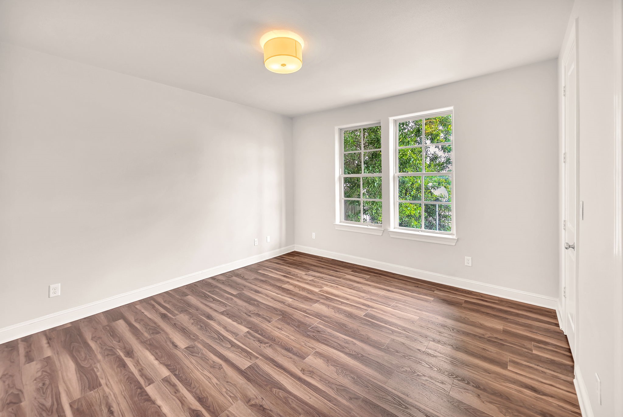 9644 Knight Road Houston, TX 77045 - Photo 6 of 28 an empty room with wooden floor and windows