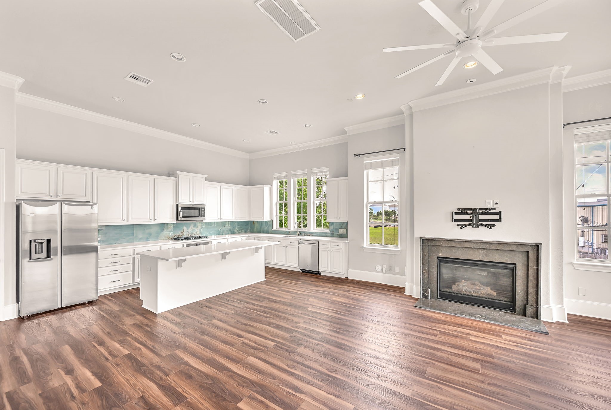 9644 Knight Road Houston, TX 77045 - Photo 9 of 28 a large kitchen with cabinets wooden floor and a fireplace