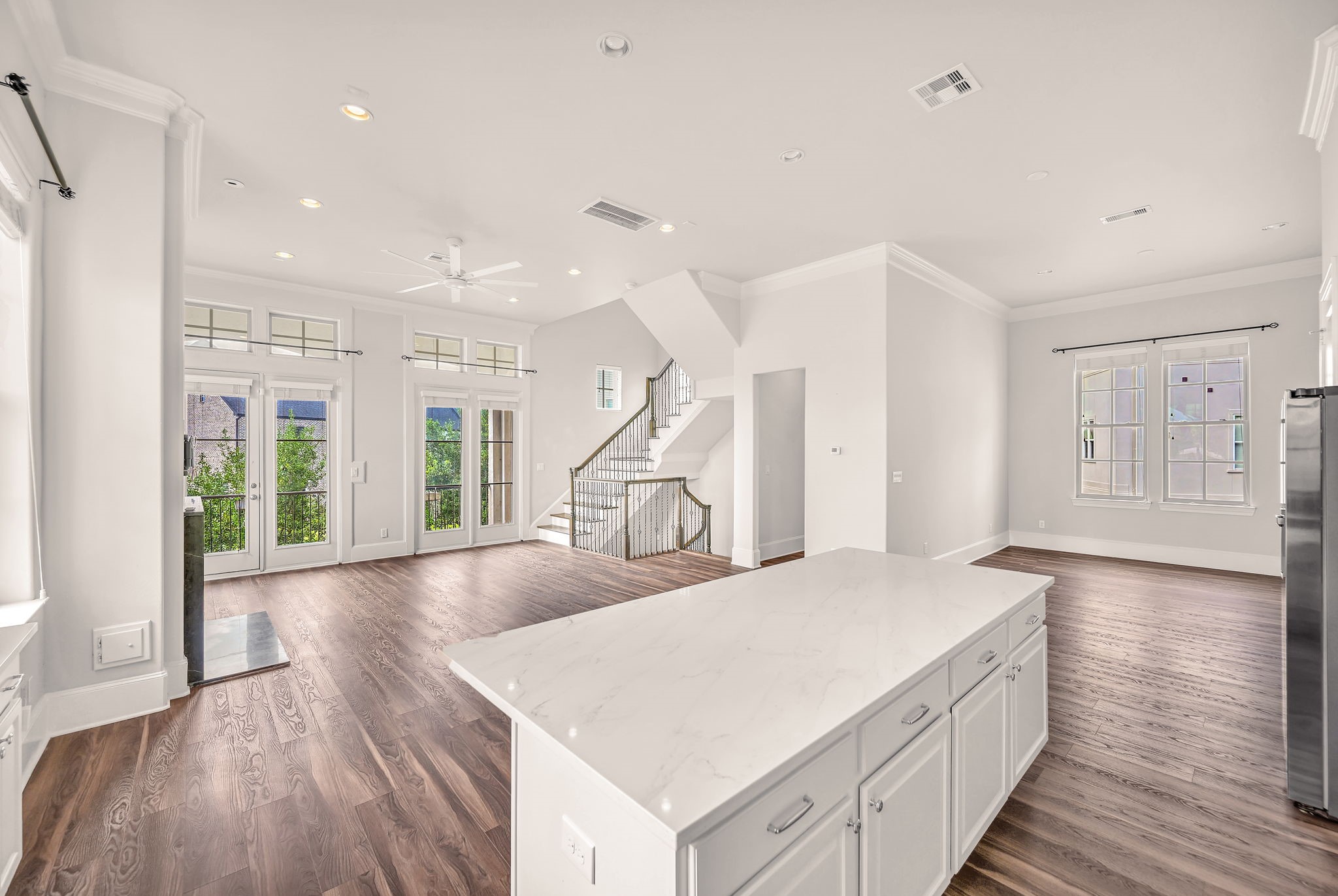 9644 Knight Road Houston, TX 77045 - Photo 10 of 28 a living room with kitchen island granite countertop wooden floor and a ceiling fan