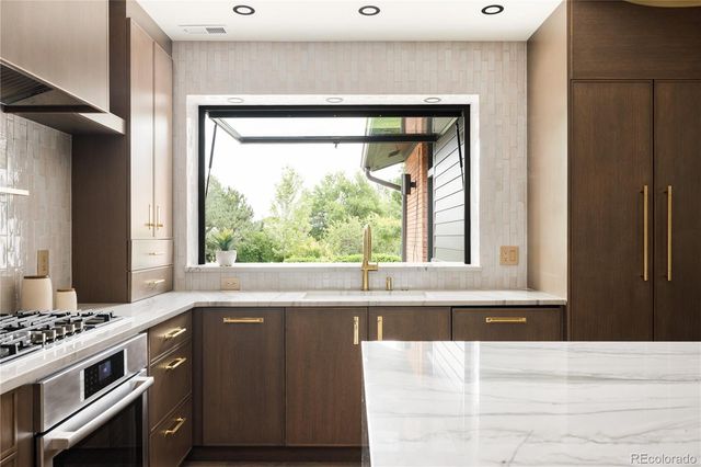 a kitchen with a stove a sink and a window