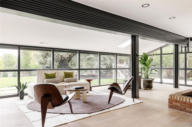 a living room with furniture and floor to ceiling windows
