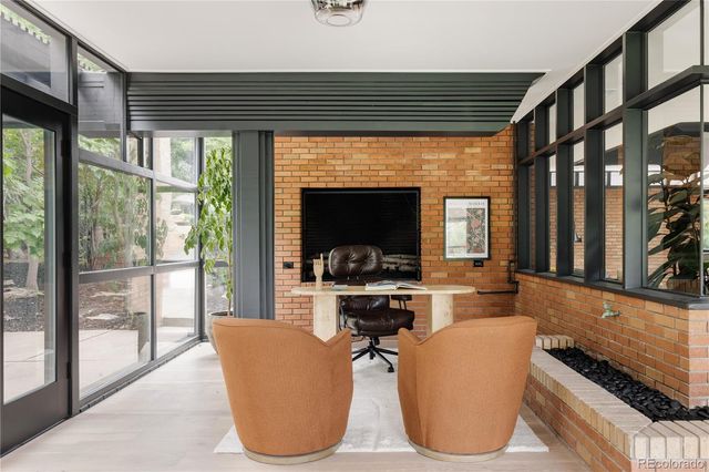 a living room with furniture a flat screen tv and a floor to ceiling window