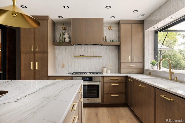 a kitchen with stainless steel appliances granite countertop a stove a sink and a microwave