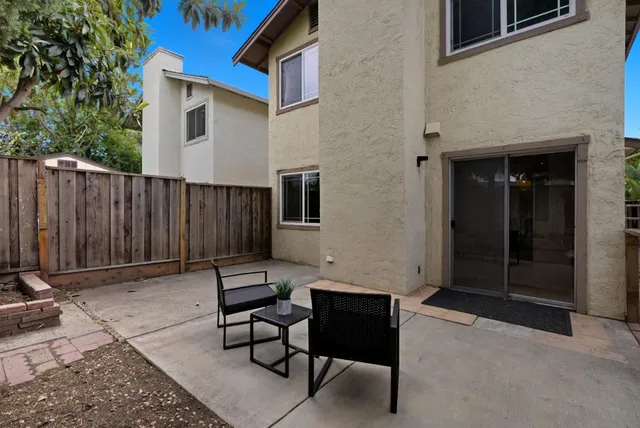 a view of a chairs and bench in the backyard of the house