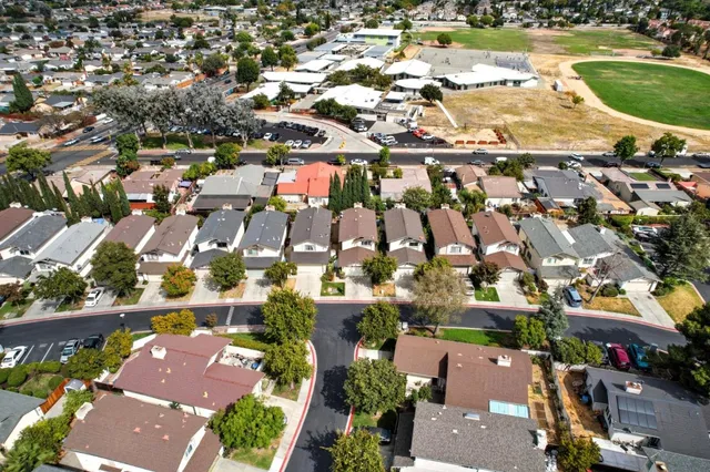 an aerial view of residential houses with outdoor space and parking