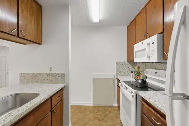 a kitchen with stainless steel appliances granite countertop a sink stove and cabinets