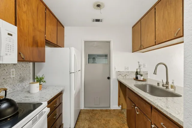 a kitchen with stainless steel appliances granite countertop a sink refrigerator and cabinets