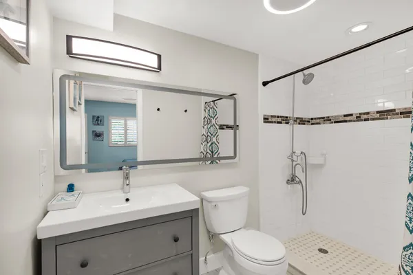 a bathroom with a toilet sink shower and mirror