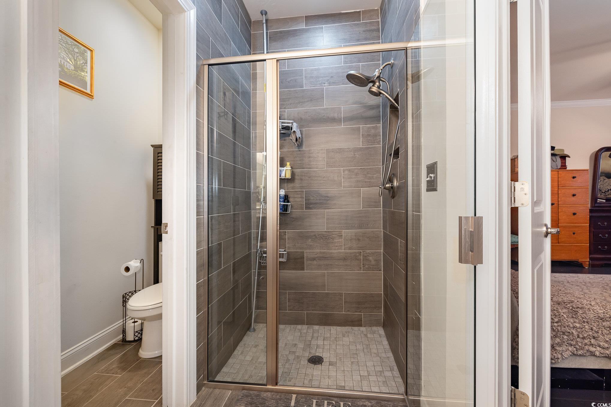 5247 Stockyard Loop Myrtle Beach, SC 29588 - Photo 17 of 39 Bathroom with a shower with door, toilet, crown molding, and hardwood / wood-style flooring