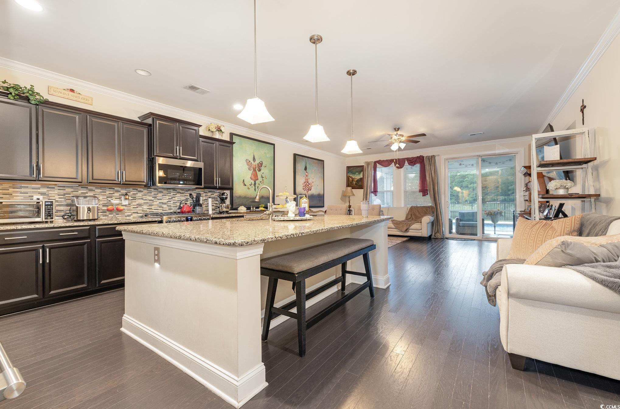 5247 Stockyard Loop Myrtle Beach, SC 29588 - Photo 8 of 39 Kitchen with ceiling fan, pendant lighting, a center island with sink, and a kitchen breakfast bar