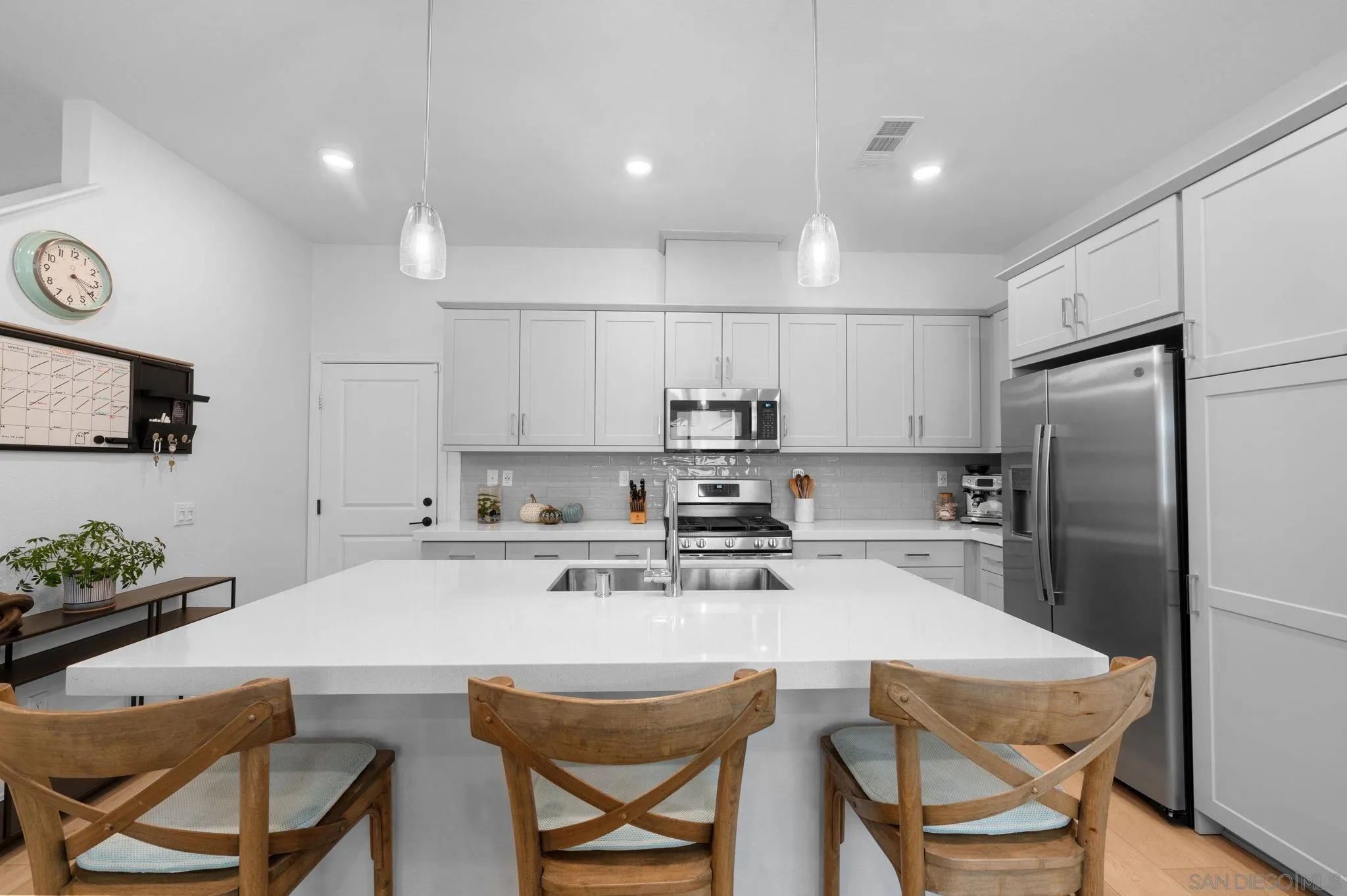 2023 Bluestone Circle Chula Vista, CA 91913 - Photo 16 of 51 a kitchen with stainless steel appliances a table chairs refrigerator and microwave