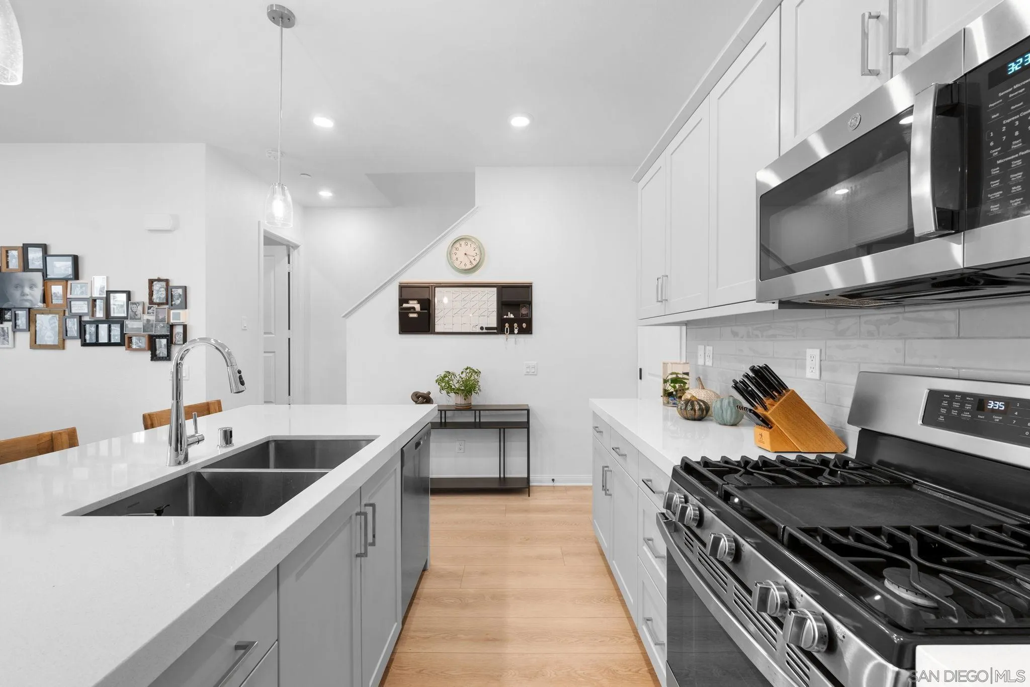 2023 Bluestone Circle Chula Vista, CA 91913 - Photo 19 of 51 a kitchen with stainless steel appliances a sink dishwasher stove microwave and cabinets