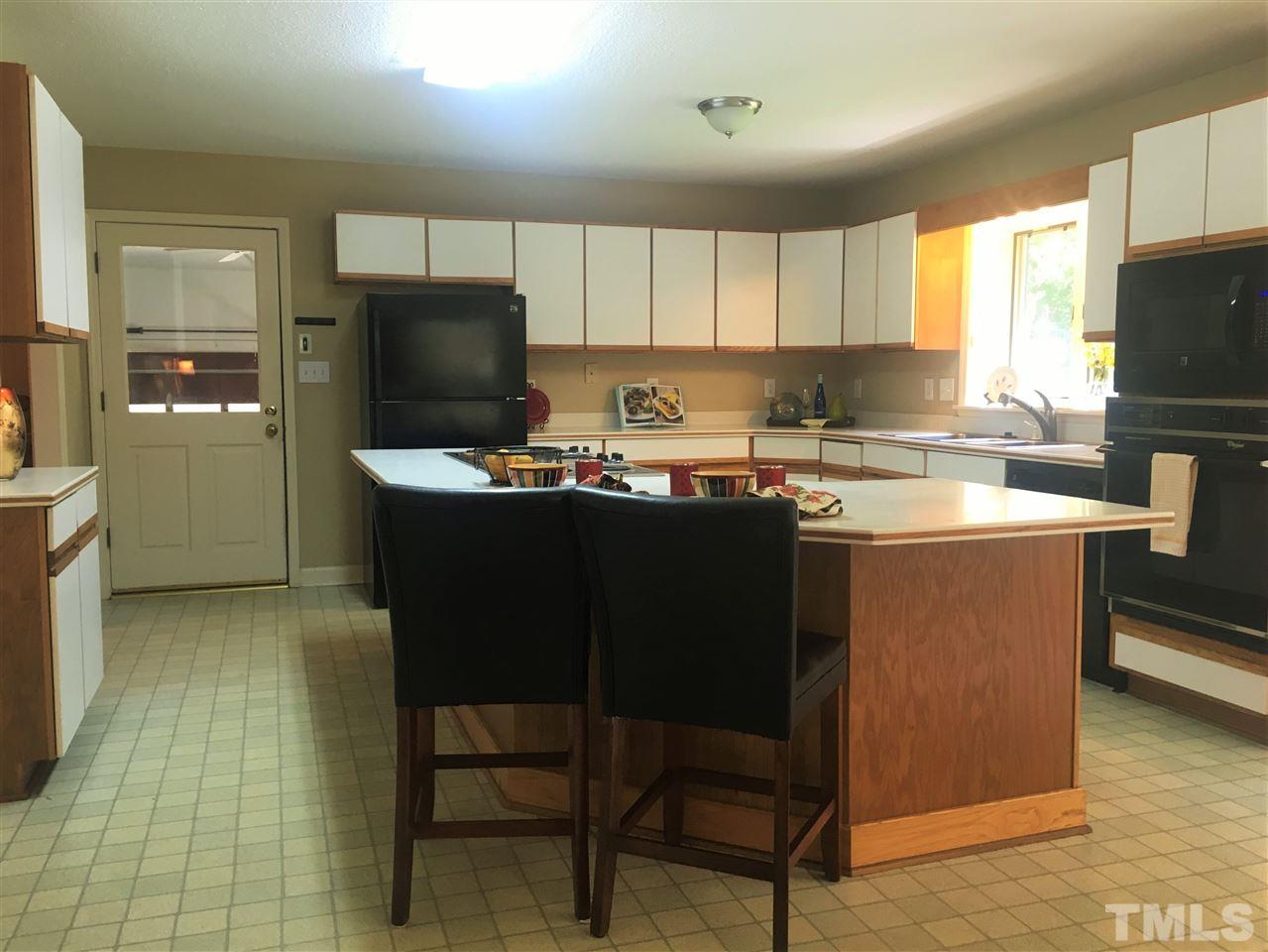 10200 Old Creedmoor Road Raleigh, NC 27613 - Photo 16 of 24 a kitchen with a sink a stove a refrigerator and chairs