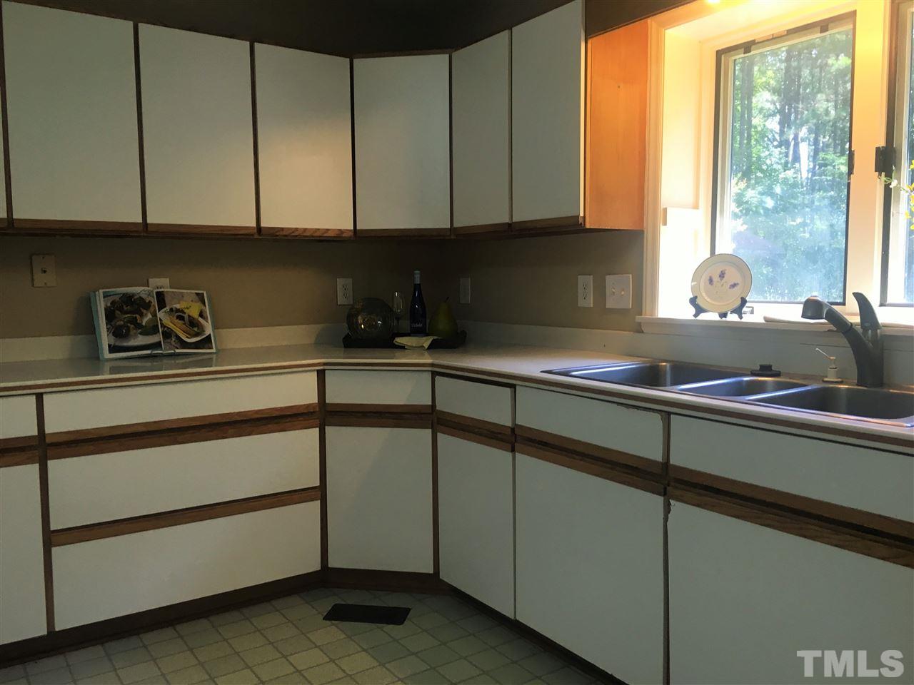 10200 Old Creedmoor Road Raleigh, NC 27613 - Photo 17 of 24 a kitchen with sink cabinets and window