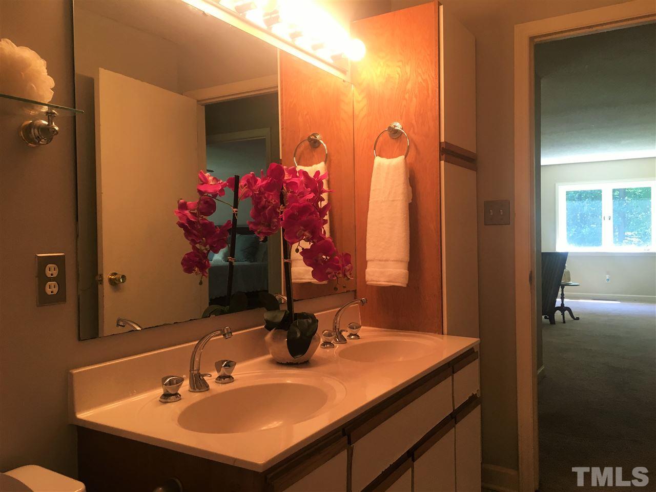 10200 Old Creedmoor Road Raleigh, NC 27613 - Photo 5 of 24 a bathroom with a sink vanity and a mirror