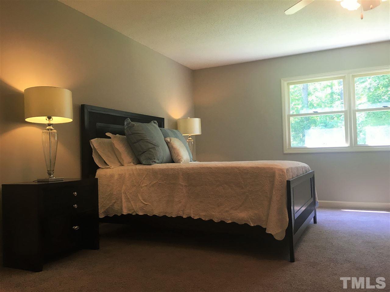 10200 Old Creedmoor Road Raleigh, NC 27613 - Photo 9 of 24 a bed sitting in a bedroom next to a window