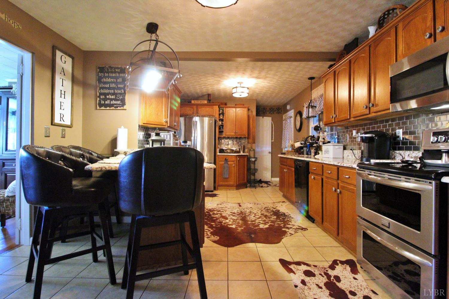1147 Union Church Road Gladstone, VA 24553 - Photo 23 of 89 a kitchen with stainless steel appliances kitchen island granite countertop a stove a sink dishwasher a dining table and chairs with wooden floor