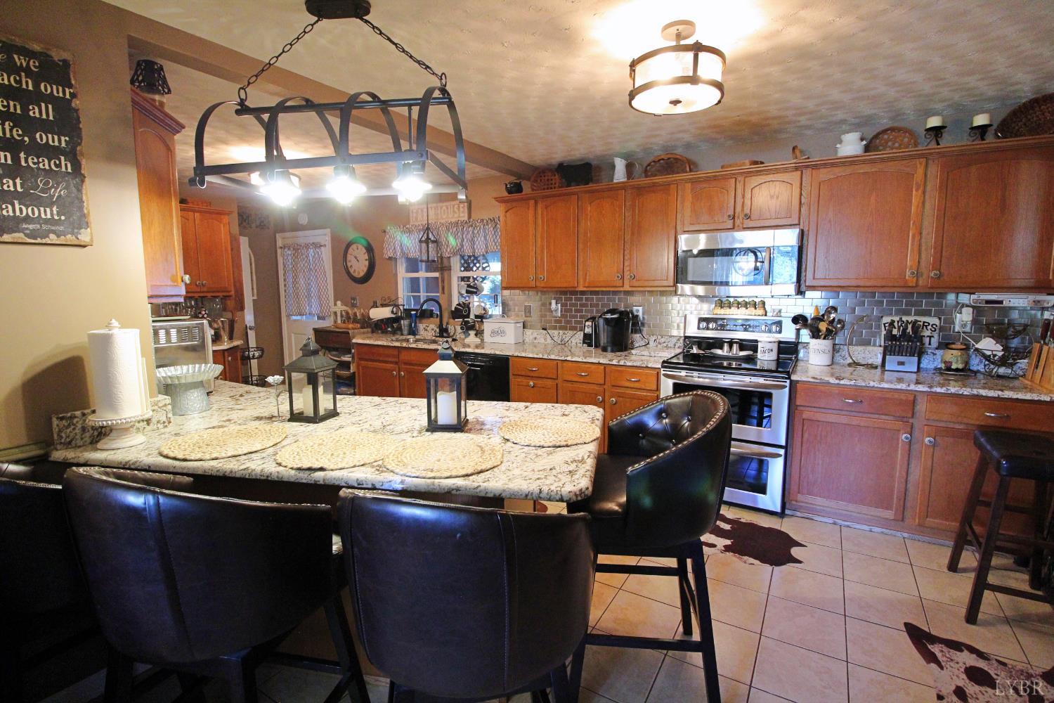 1147 Union Church Road Gladstone, VA 24553 - Photo 24 of 89 a kitchen with stainless steel appliances granite countertop a sink dishwasher a stove a dining table and chairs with wooden floor
