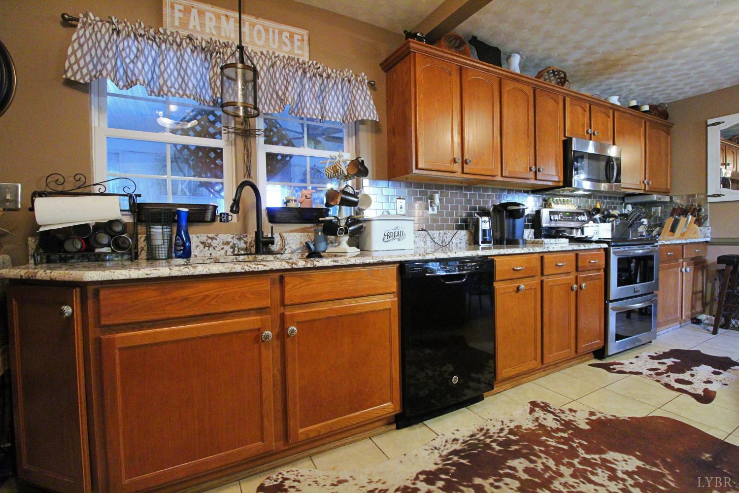 1147 Union Church Road Gladstone, VA 24553 - Photo 27 of 89 a kitchen with stainless steel appliances granite countertop wooden cabinets a stove top oven a sink and dishwasher