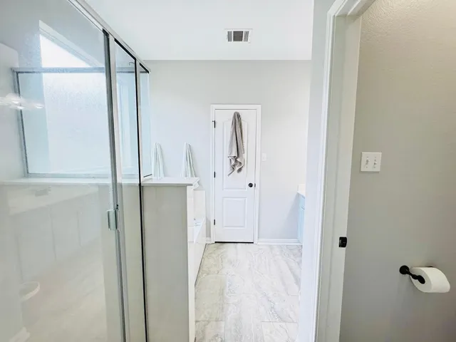 a view of a bathroom with a glass door shower