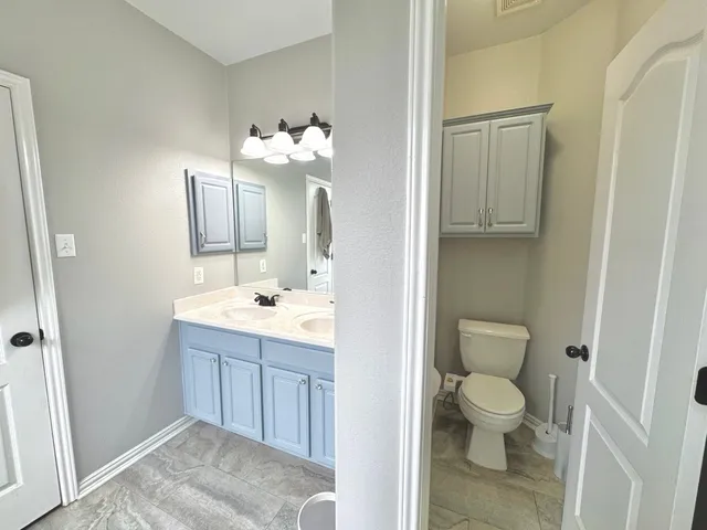 a bathroom with a toilet sink and mirror