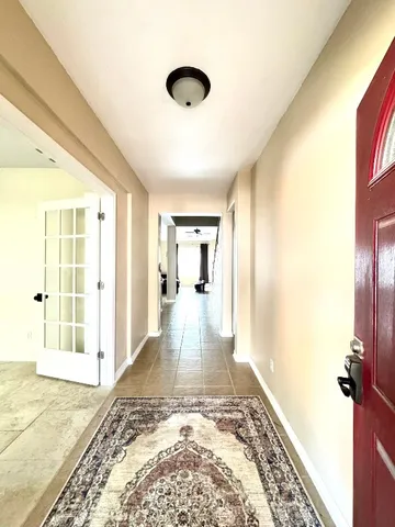 a view of a hallway to a livingroom with wooden floor
