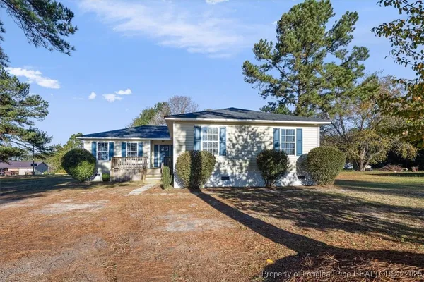 a view of a house with a yard and sitting area