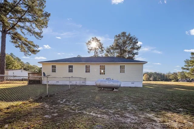 a view of a house with a yard and a large tree