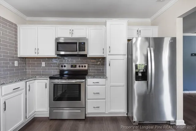 a kitchen with cabinets stainless steel appliances and a counter space