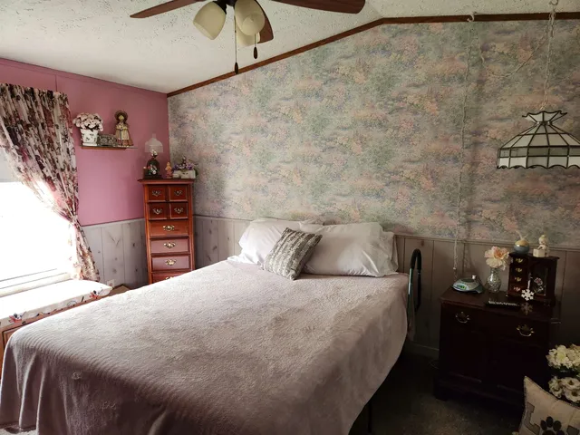 a bedroom with a bed and a lamp on the dresser