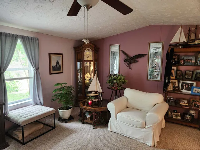 a living room with furniture a bookshelf and a window