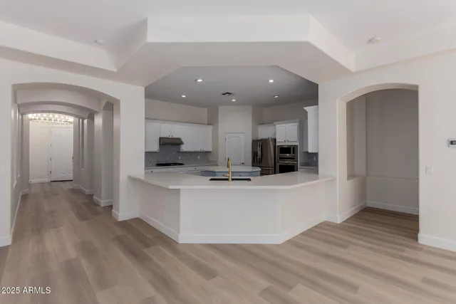 a kitchen with stainless steel appliances granite countertop a refrigerator and a stove top oven