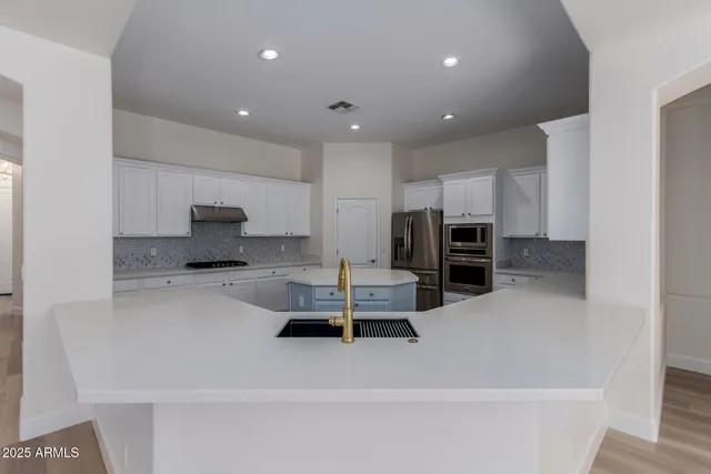 a kitchen with granite countertop a sink and white cabinets