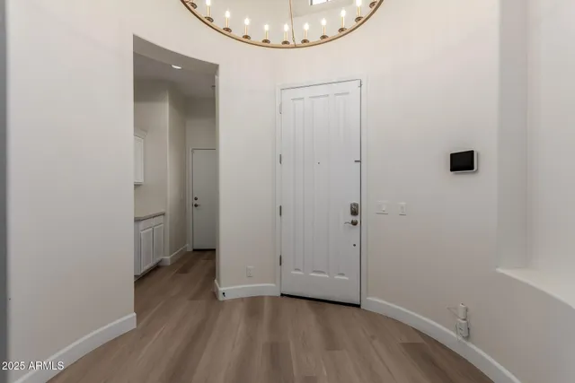 an empty room with wooden floor and mirror